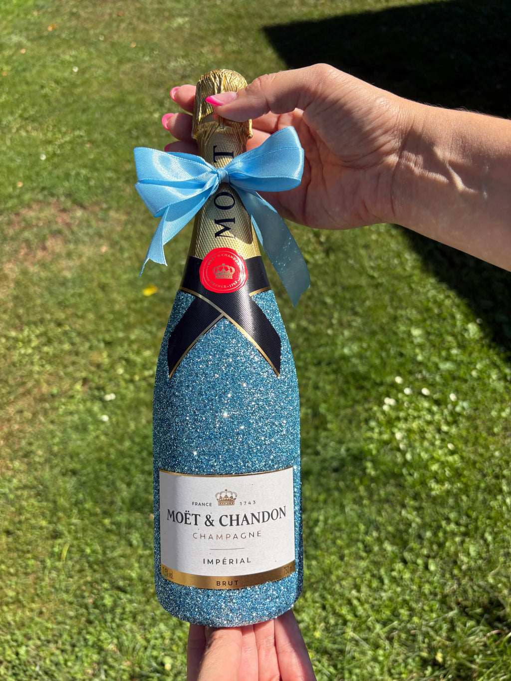 Moet Chandon brut zdobený světle modrýma třpytkama. Dressbottle
