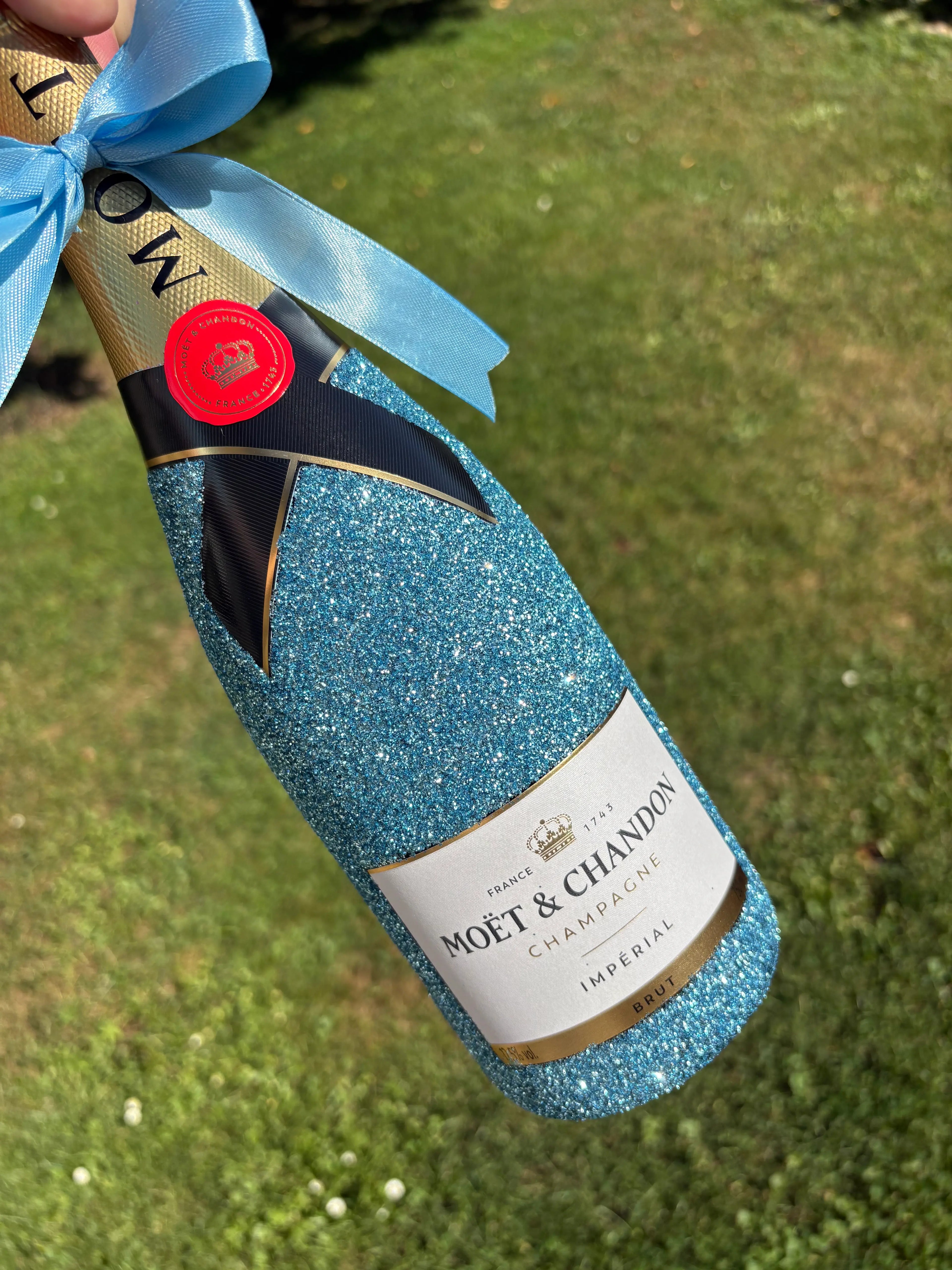 Moet Chandon brut zdobený světle modrýma třpytkama. Dressbottle